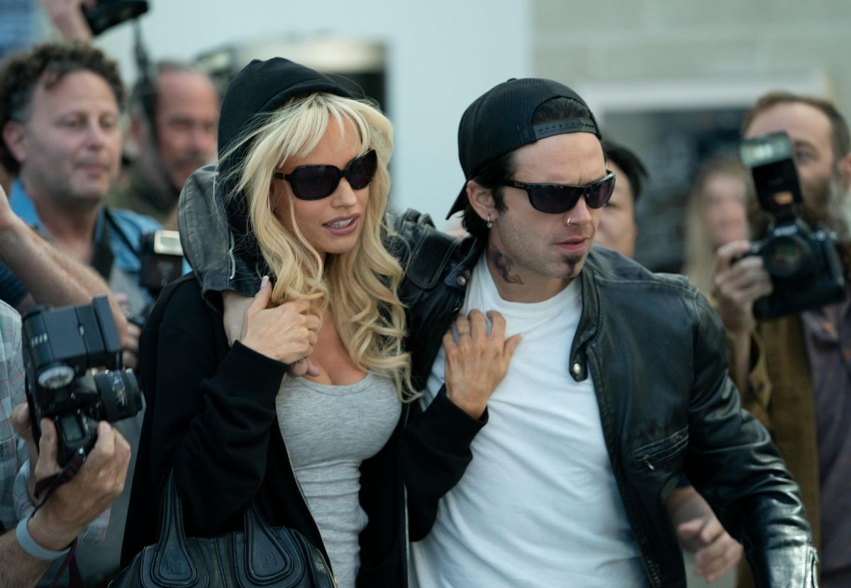 Pamela Anderson (Lily James) and Tommy Lee (Sebastian Stan) escape the paparazzi in Pam & Tommy