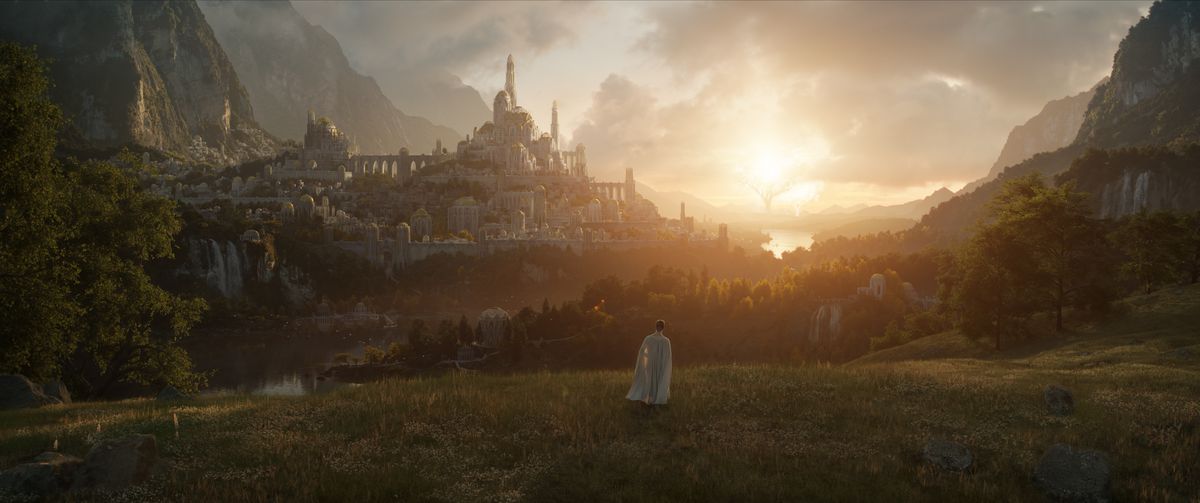 a woman in a white cape stands on a grassy ridge overlooking an elven city in Amazon Studios’ untitled Lord of the Rings TV series