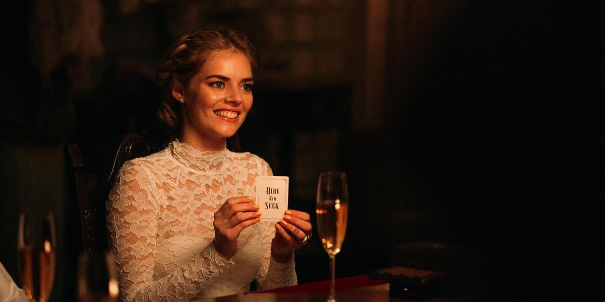 Una donna in abito da sposa tiene in mano un cartello che dice