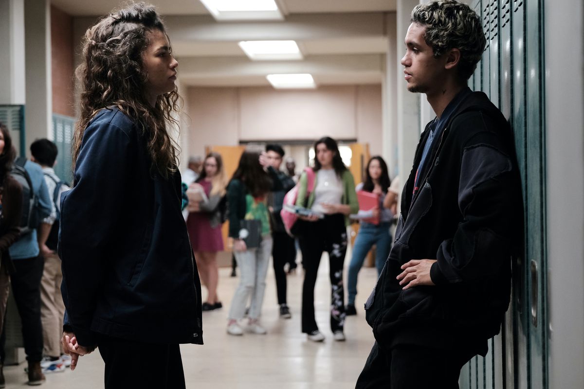 Zendaya, Dominic Fike standing in a high school hallway in Euphoria