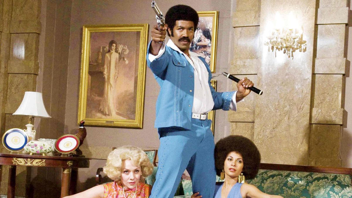 Black Dynamite in posa con pistola e nunchaku.