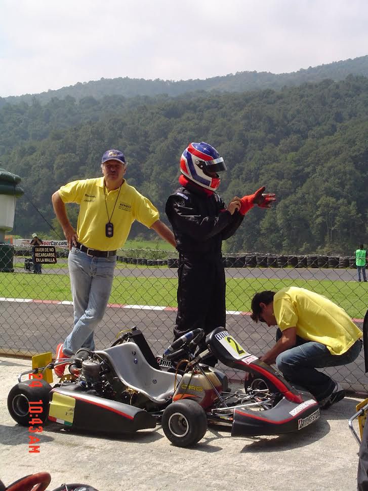 un pilota con il casco indossa i guanti da corsa prima di prendere posto su un kart di Formula A
