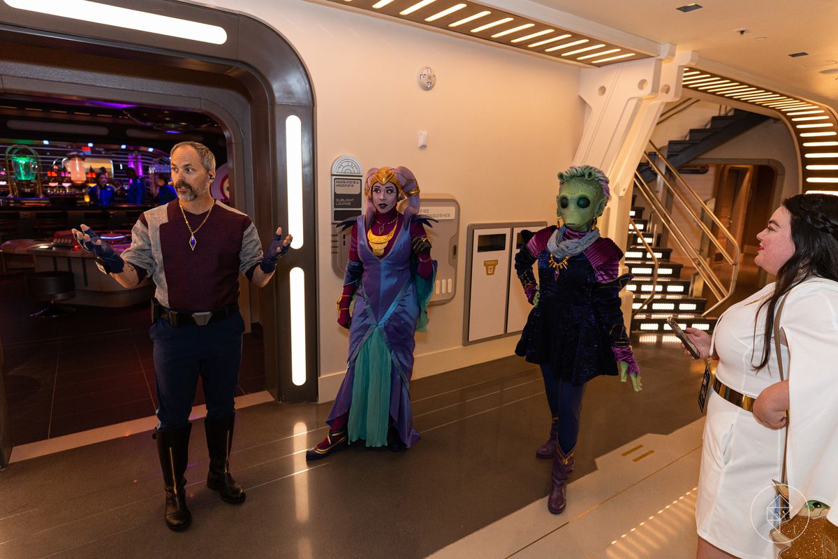 Un umano burbero, un Twi'lek e un Rhodiian accolgono gli ospiti nell'atrio fuori dal bar.