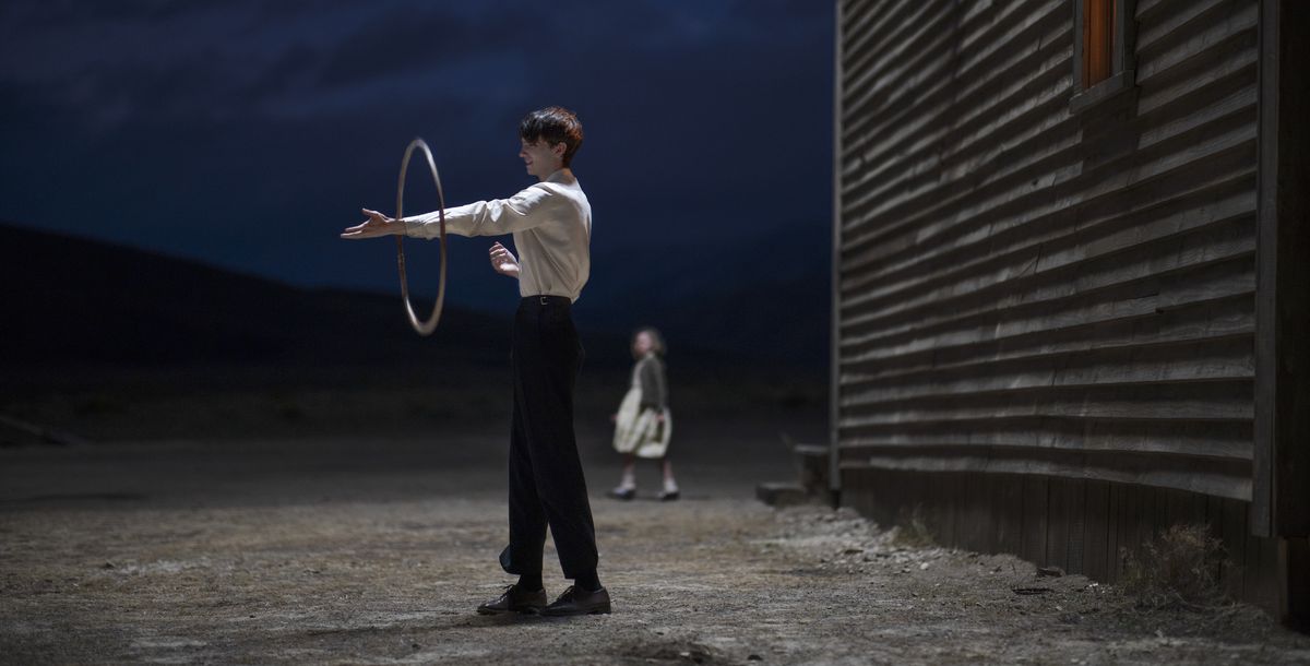 Kodi Smit-McPhee nei panni di Peter in piedi fuori, giocando con un hulu hoop di notte in The Power of the Dog