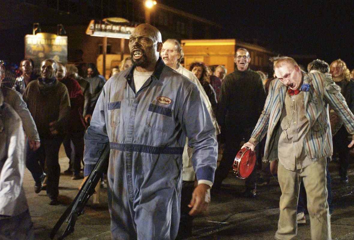 Una massa di zombi che marcia lungo una strada deserta in Land of the Dead.