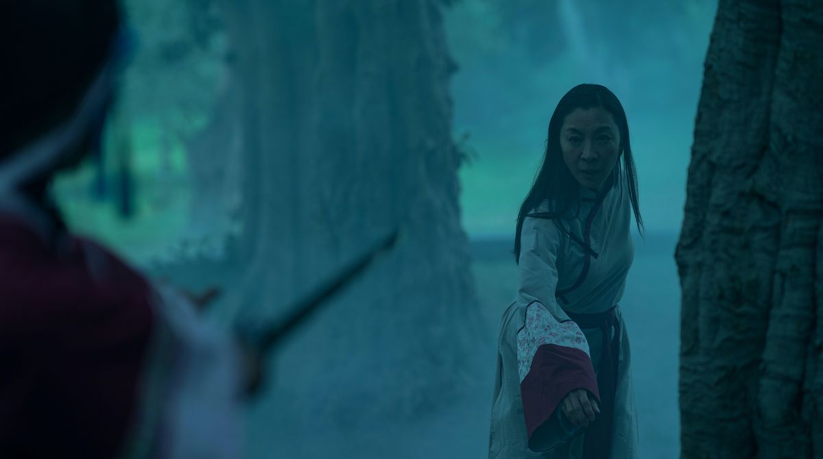 Michelle Yeoh, in abiti da hanfu d'epoca, torna in una foresta mentre un aggressore fuori campo le punta una spada in Tutto ovunque tutto in una volta