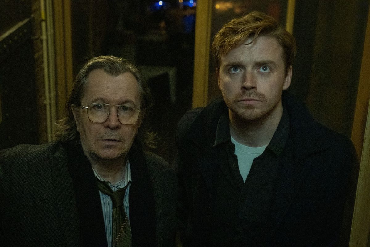Gary Oldman e Jack Lowden sembrano preoccupati in un corridoio