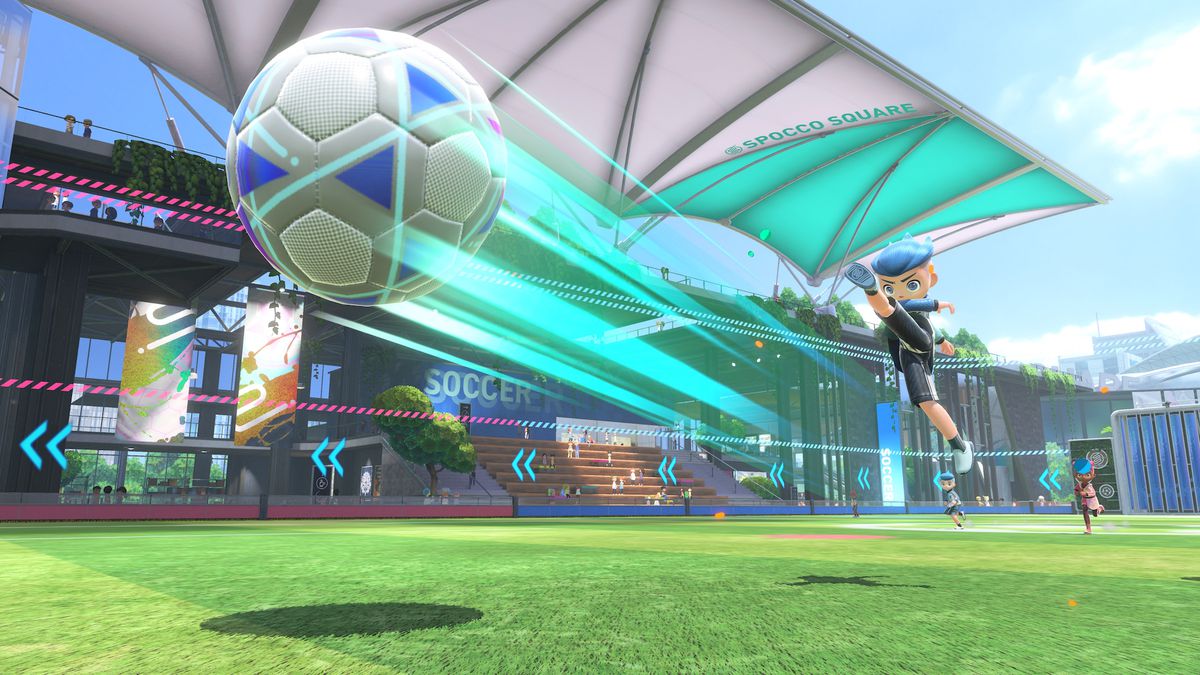 Un giocatore con i capelli blu calcia un pallone da calcio gigante in uno screenshot di Nintendo Switch Sports