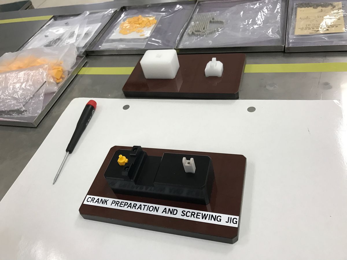 Una stazione di preparazione della manovella e di avvitamento della maschera mostra gli strumenti e il processo utilizzati da Panic per costruire le unità di prova Playdate