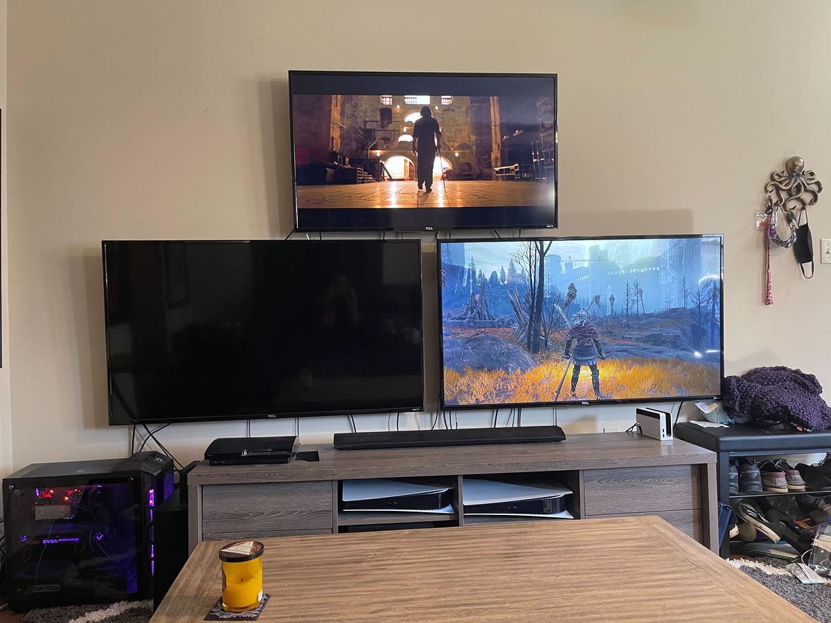 La TV sinistra è vuota. La TV di destra mostra Elden Ring mentre la TV in alto mostra Moon Knight