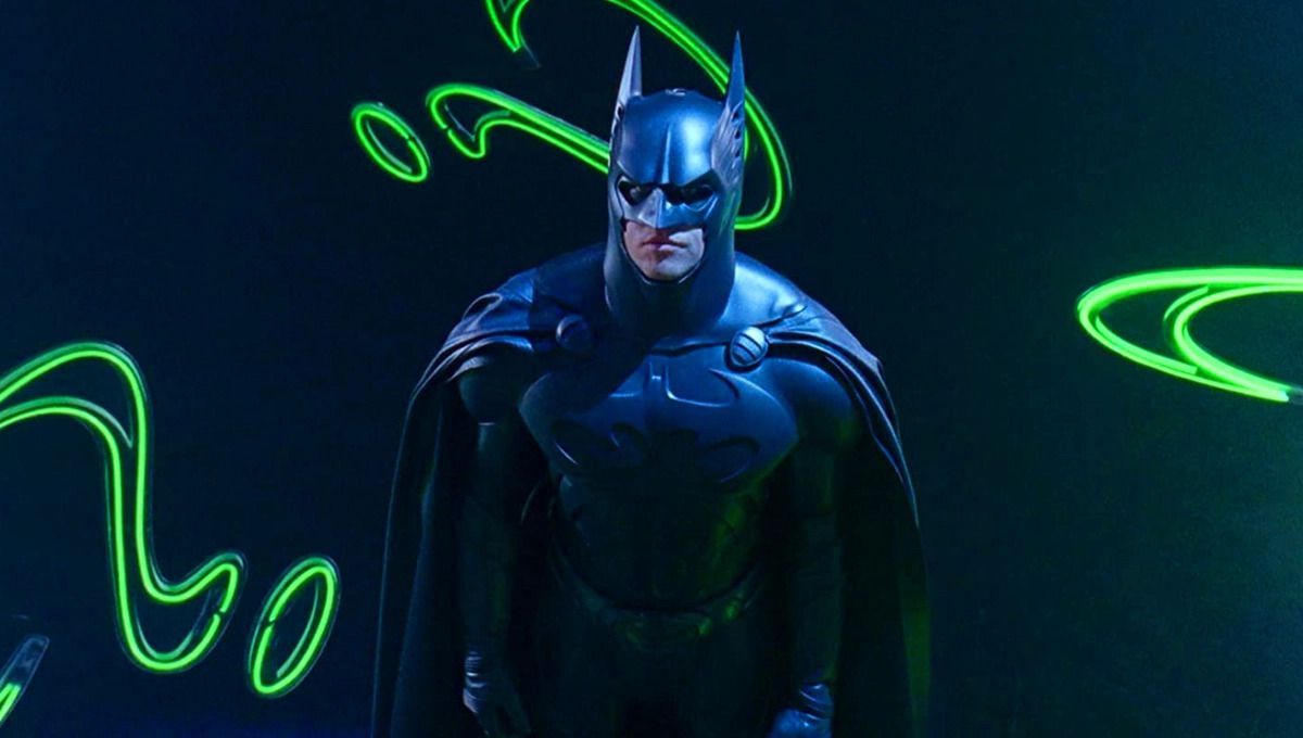 Val Kilmer nei panni di Batman circondato da punti interrogativi al neon luminosi in Batman Forever.