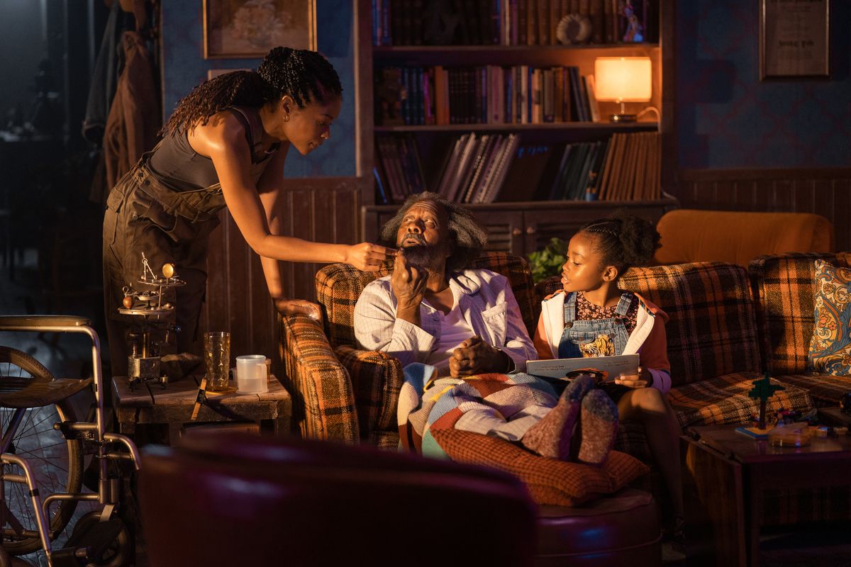 Justin aiuta suo padre, che è seduto su un divano accanto a sua figlia in The Man Who Fell from Earth