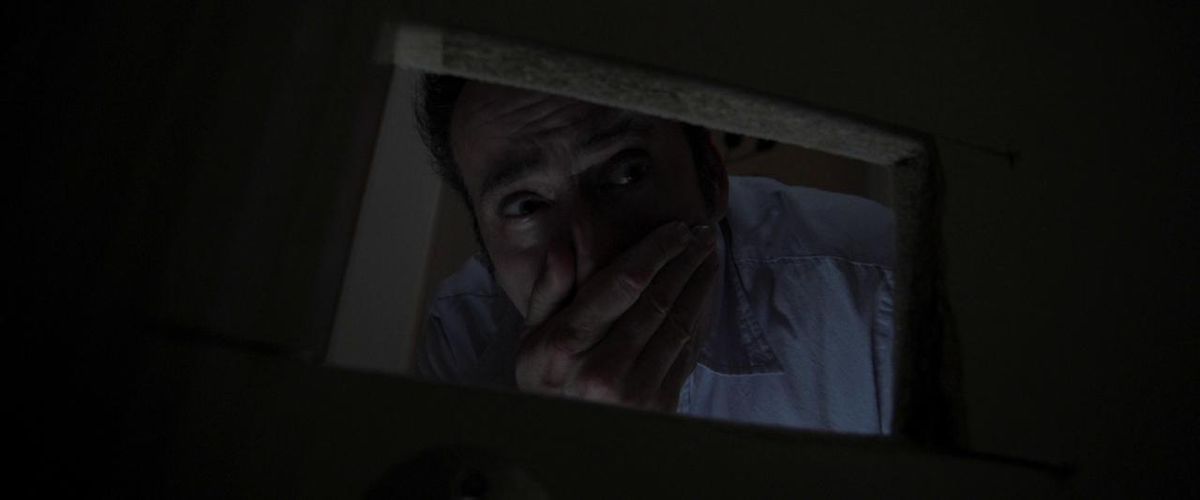 Nicolas Cage incorniciato da un buco quadrato nel muro in Mamma e papà.