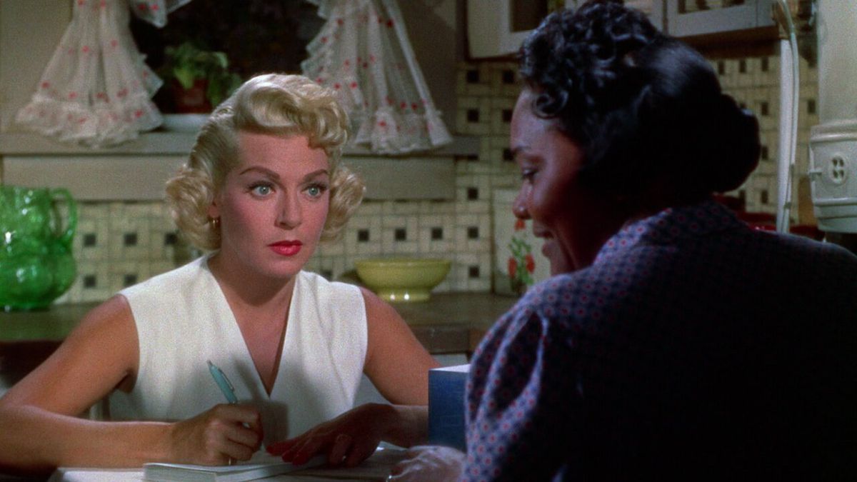 Lora (Lana Turner) e Annie (Juanita Moore) sedute l'una di fronte all'altra a tavola in Imitation of life (1959).