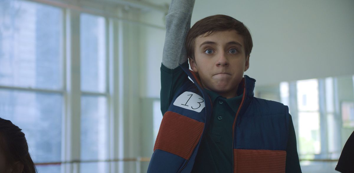 Nate alzando con entusiasmo la mano per offrirsi volontario per qualcosa