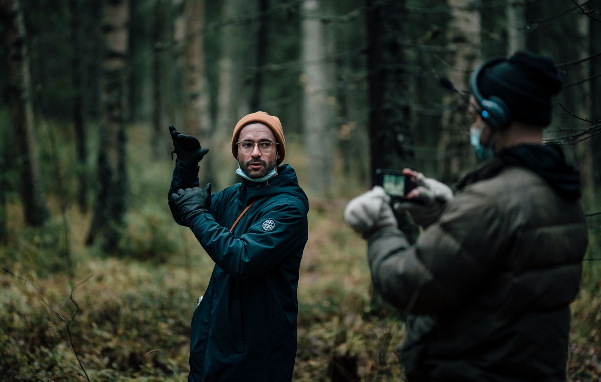 Il regista Riley Stearns e un cameraman preparano una ripresa nel bosco in Dual