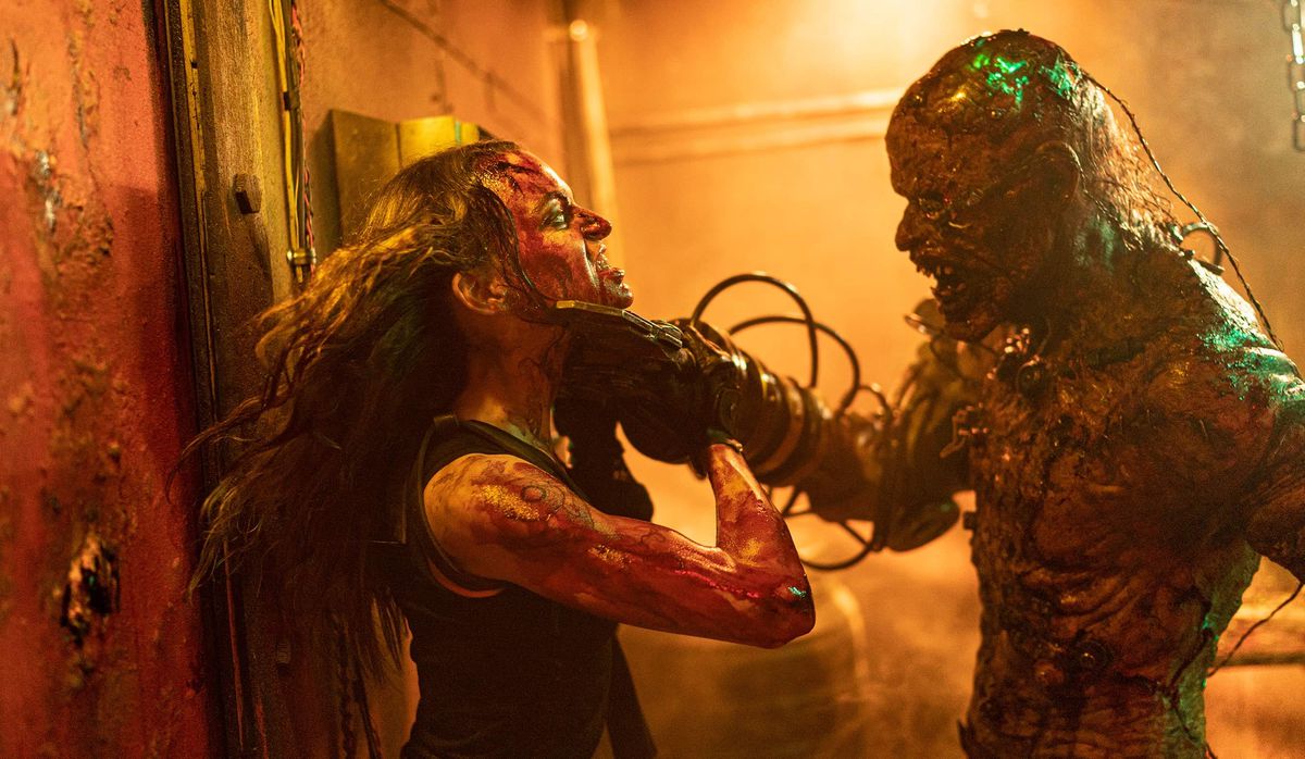 Cyborg Zombie (Alex Jewson) strangola Brooke (Bianca Bradey) in Wyrmwood: Apocalypse.