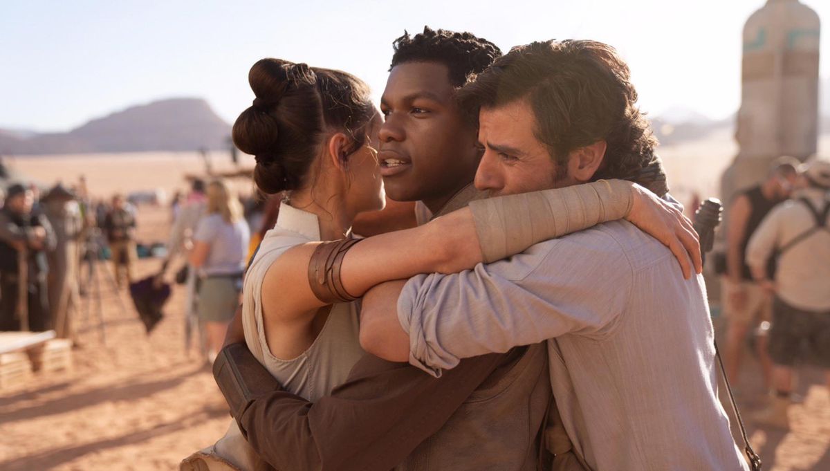 Rey (Daisy Ridley), Poe (Oscar Isaac) e Finn (John Boyega) si abbracciano in un momento di trionfo, perché l'emozione non è così male come dicono i Jedi