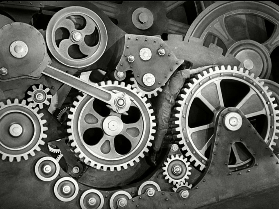 Charlie Chaplin è un ingranaggio in una macchina, che viaggia attraverso gli ingranaggi in Modern Times.