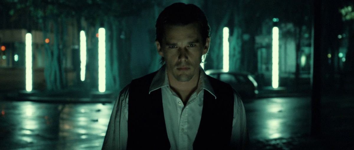 Ethan Hawke è pensieroso nei confronti di una città di notte in Daybreakers.