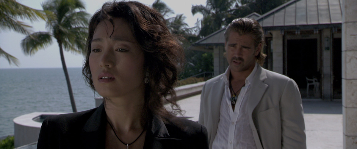 Colin Farrell e Gong Li davanti al soleggiato scenario di Miami.