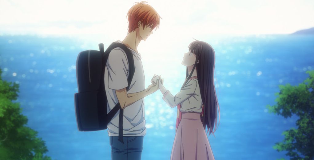 Due dei personaggi di Fruits Basket: Prelude si tengono per mano, si staglia contro il mare