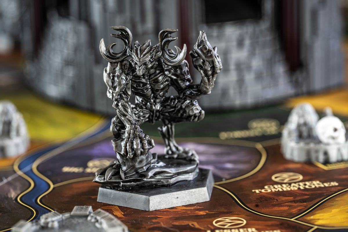 Un gigante grottesco con in mano una corona fiammeggiante di teschi.