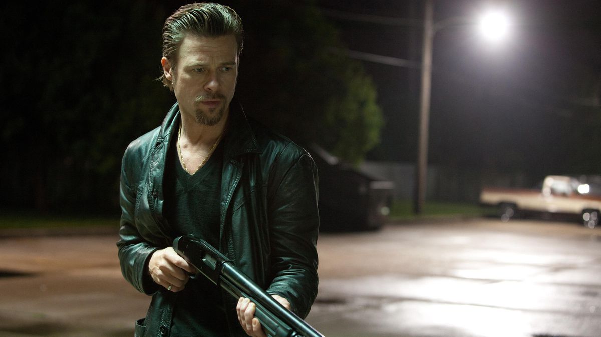 Brad Pitt con i capelli lisci con in mano un fucile in Killing Them Softly