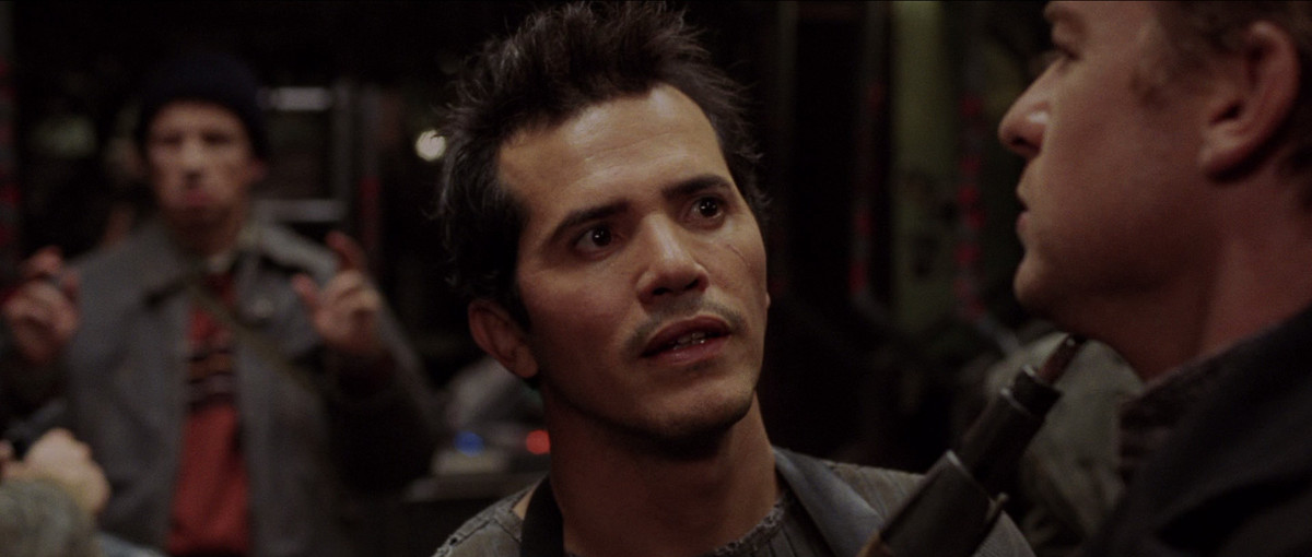 John Leguizamo punta una pistola al collo di Simon Baker in Land of the Dead.