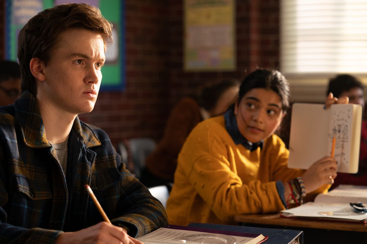 kamala e bruno in classe; gli sta mostrando qualcosa che ha scarabocchiato sul suo taccuino