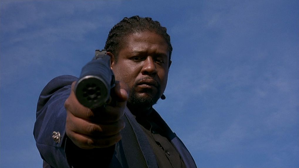 Forest Whitaker nei panni di Ghost Dog che punta una pistola silenziata in Ghost Dog: Way of the Samurai.