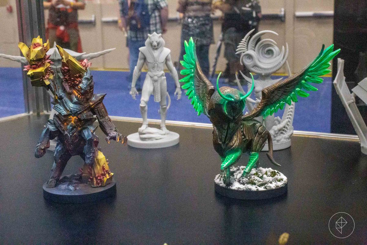 Sul tavolo stanno due enormi avatar di segni zodiacali, un mostro rock e un cavallo alato