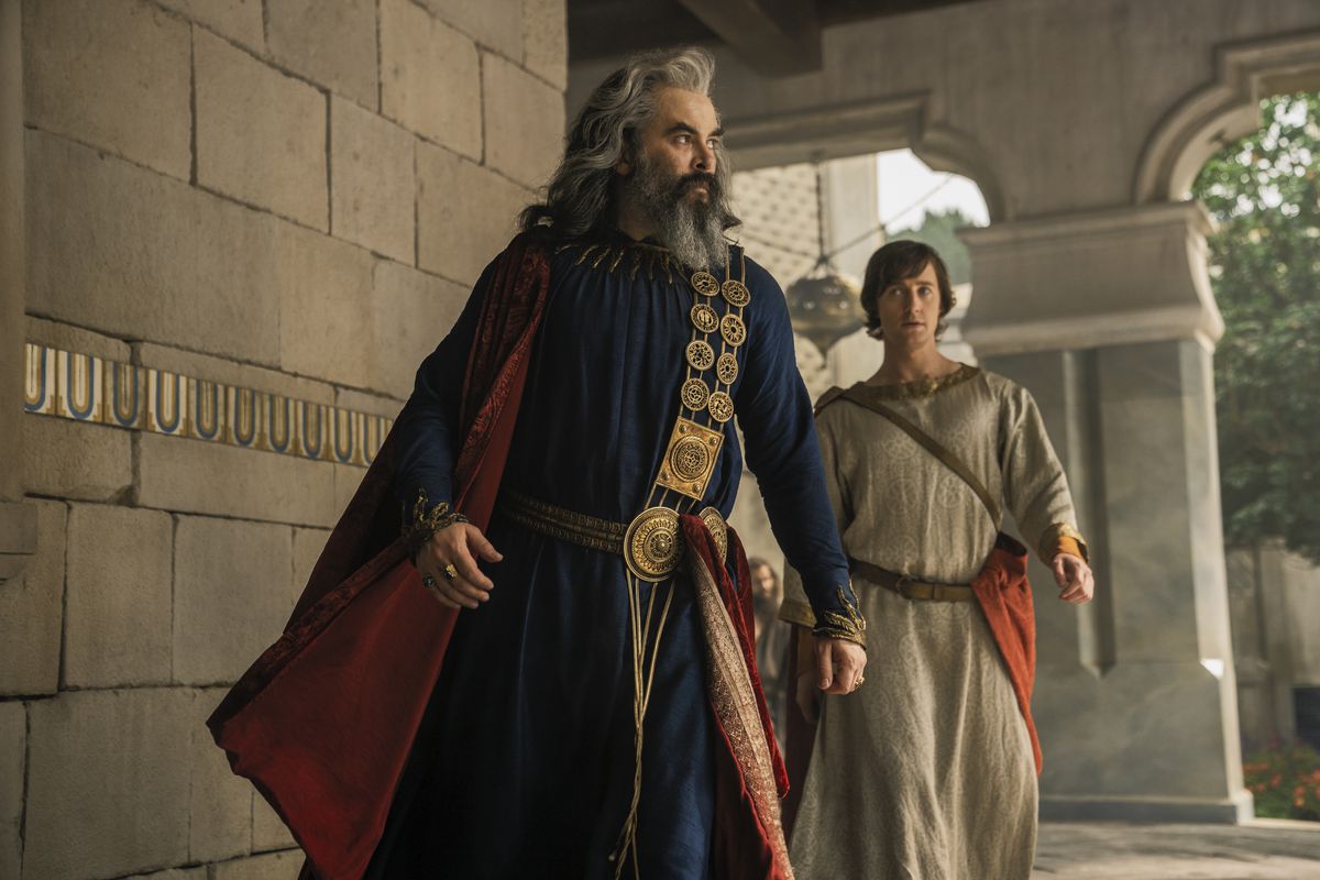 Pharazon cammina e guarda di lato mentre cammina con suo figlio dietro di lui 