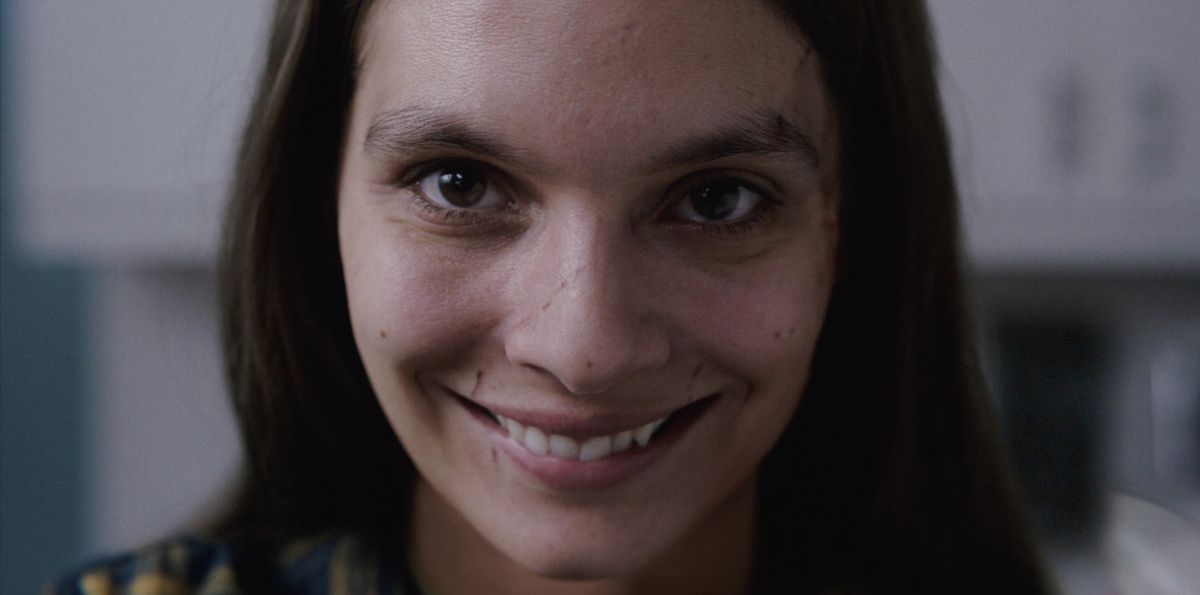 Una donna sorride con gioia diabolica in Smile