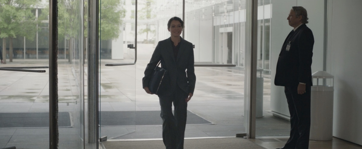 Jen Walters entra in un edificio per uffici davanti a un agente di sicurezza