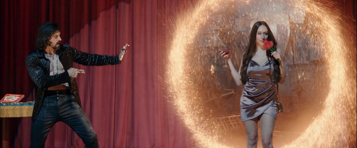 Il mago di scena Donny Blaze apre un portale verso una dimensione infernale usando alcuni veri strumenti magici dello Stregone Supremo dietro un volontario del pubblico che tiene il suo drink e alcune rose finte in She-Hulk: Attorney at Law.