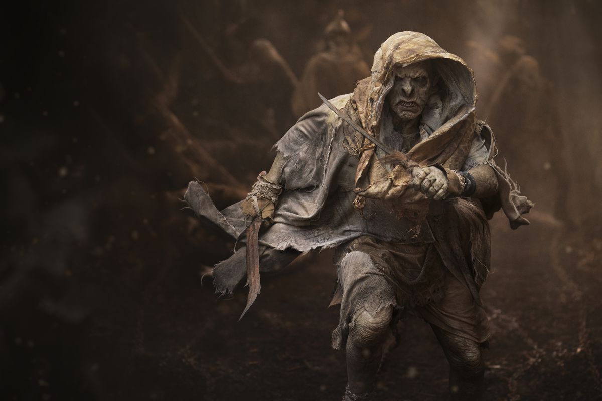 Un orco che corre e sembra intenso mentre tiene una spada in una mano e un coltello nell'altra