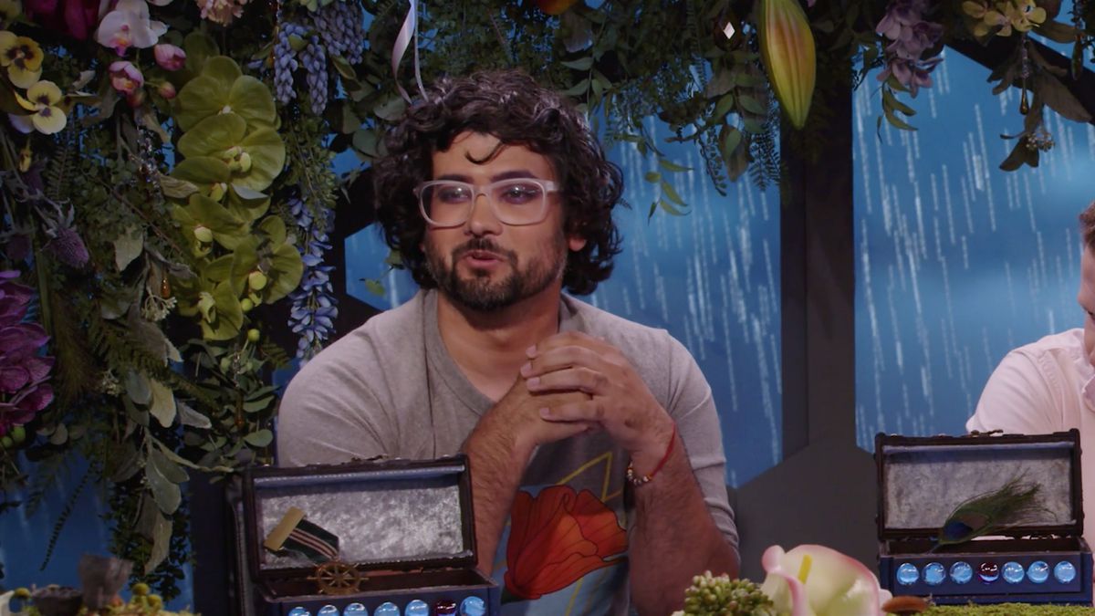 Omar Najam è seduto al tavolo, le mani giunte.