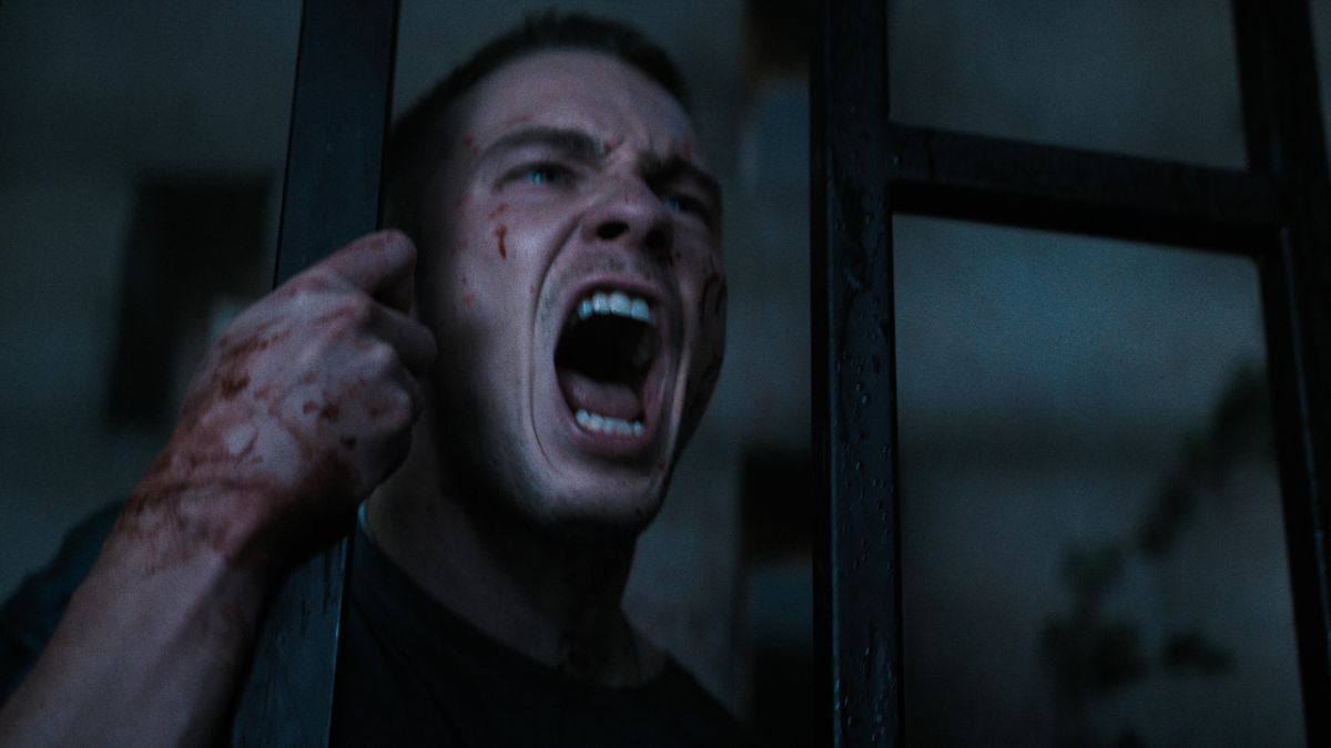 Drew Starkey urla mentre si tiene su una barra verticale con una mano insanguinata in Hellraiser.