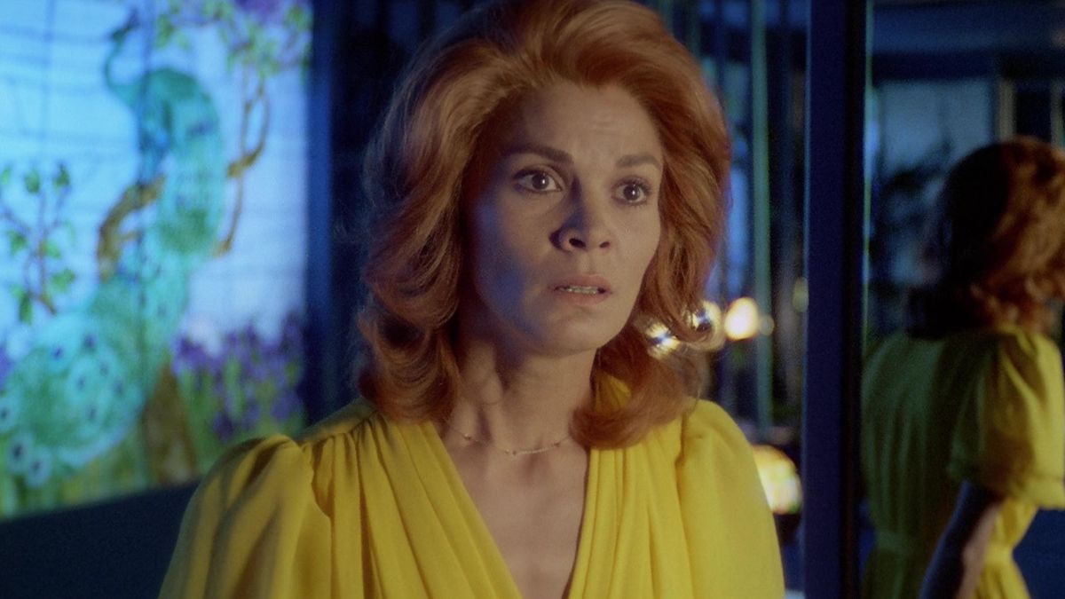 Una donna con i capelli rossi e che indossa un vestito giallo sembra sorpresa in Footprints.