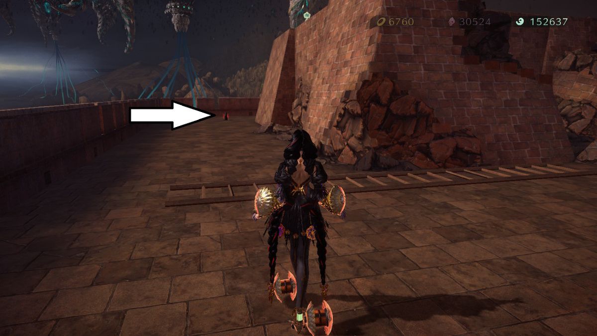 Bayonetta si avvicina a un gatto seduto in mezzo a un sentiero