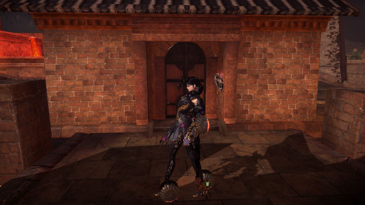 Un rospo con in mano un gioiello rosso si attacca al muro accanto a una porta.