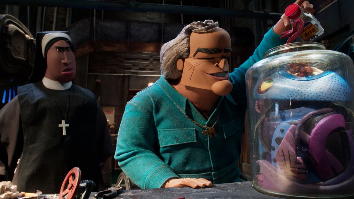 La suora Sister Helley lancia un'occhiata da sopra la spalla del bidello squinty Manfred mentre è seduto sulla sua sedia a rotelle a guardare una strana cosa dall'aspetto cubista in un barattolo nel film d'animazione in stop-motion Wendell & Wild