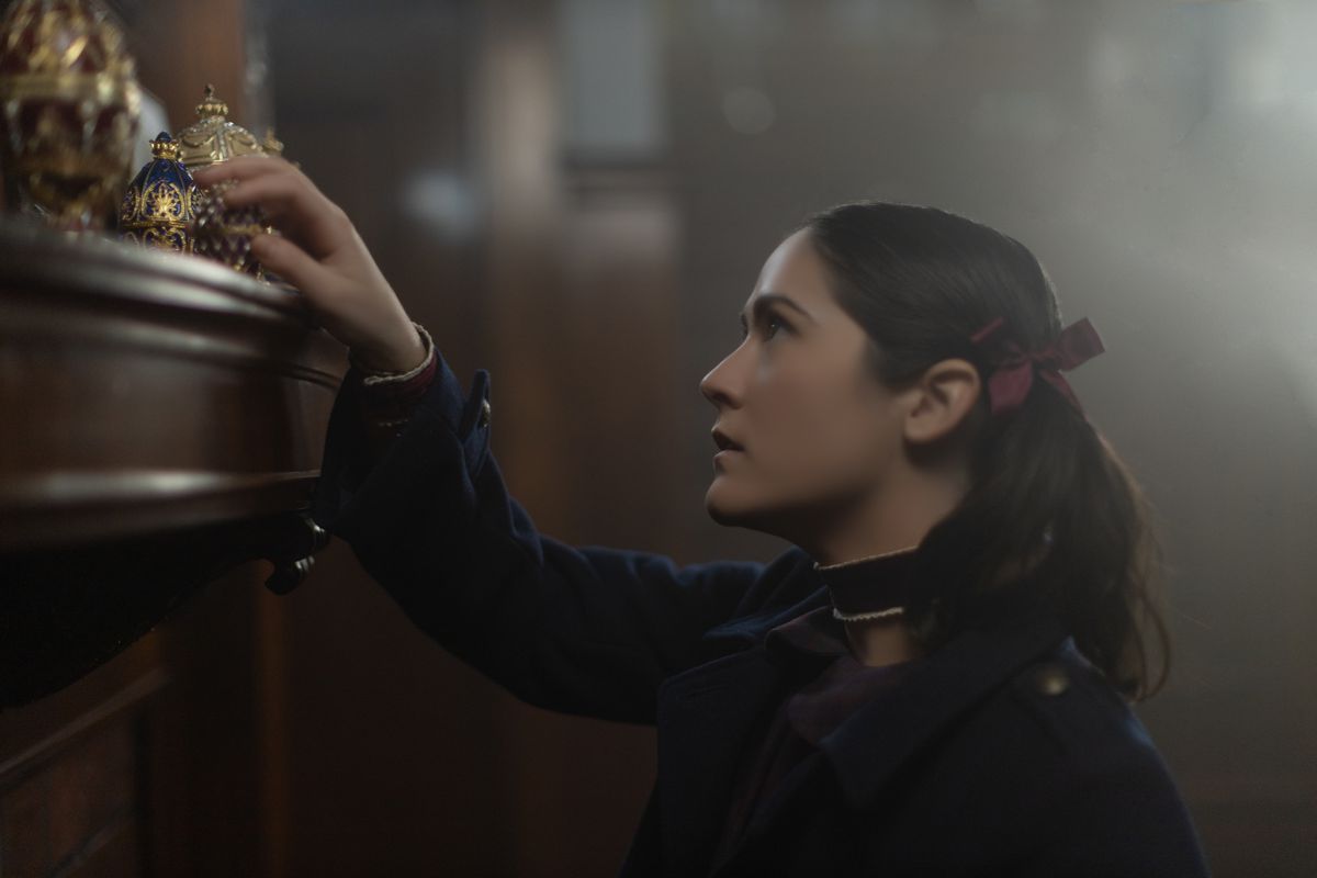 Isabelle Fuhrman nei panni di Esther in Orphan: First Kill guardando qualcosa su uno scaffale