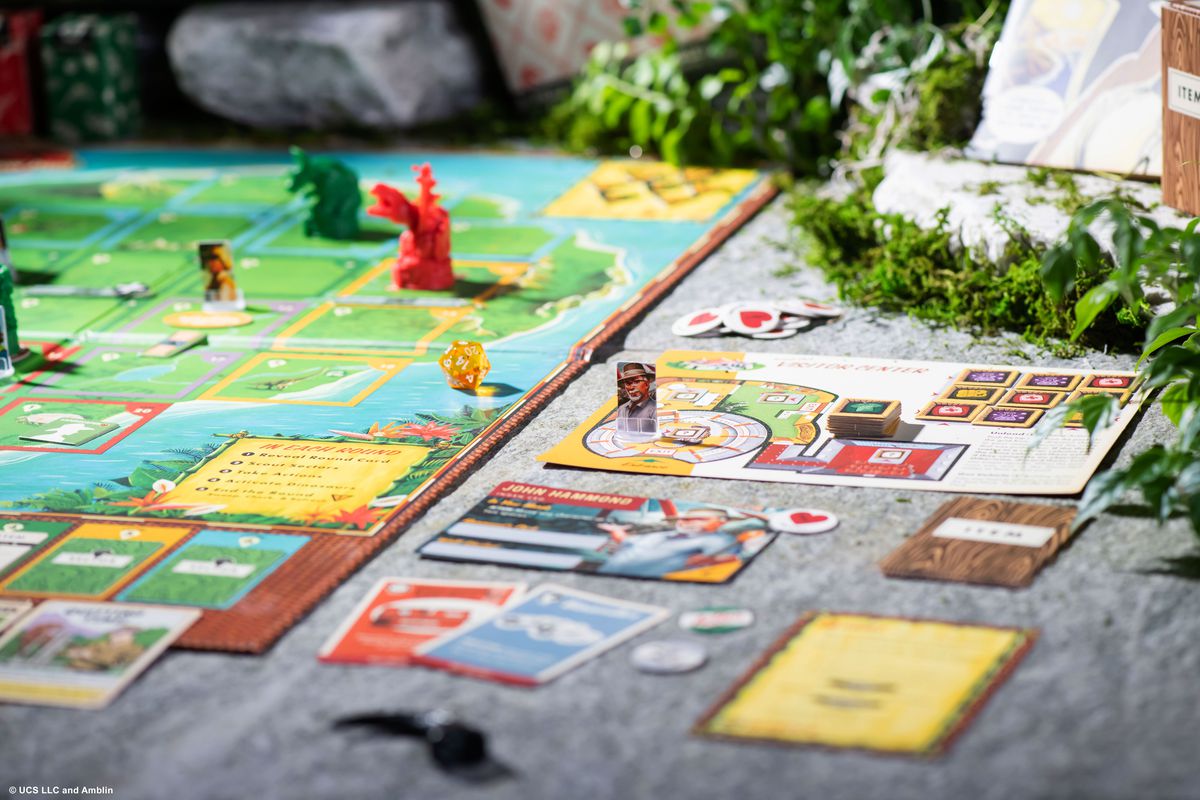 Il dottor Hammond nel centro visitatori, sposta le scatole in un gioco di combinazione a tre.