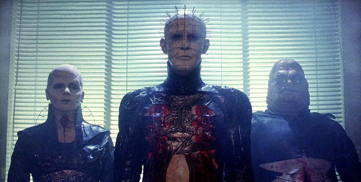 Pinhead affiancato da altri due cenobiti davanti ad alcune persiane con persiane in Hellraiser (1987)