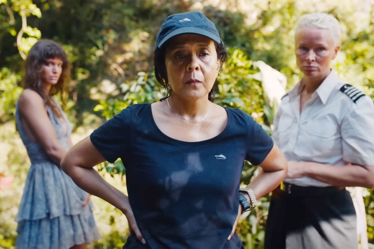 Abigail (Dolly De Leon) è in piedi con le mani sulla vita, guardando per la pazienza, con altri due passeggeri del suo yacht in piedi dietro di lei in Triangle of Sadness