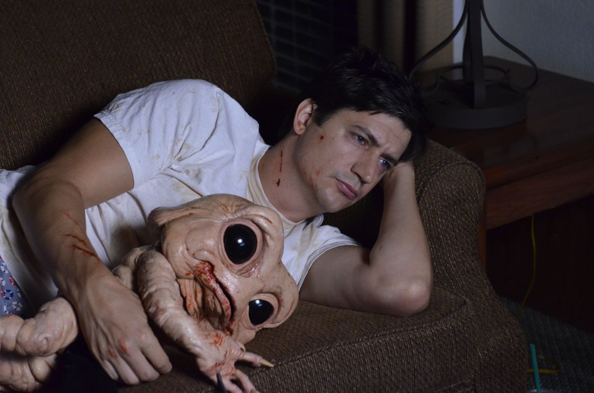 Duncan (Ken Marino) è sdraiato sul divano nella sua maglietta bianca con in braccio Milo, un demone culo che assomiglia vagamente al bambino di Dinosaurs ma con occhi giganti di Baby Yoda