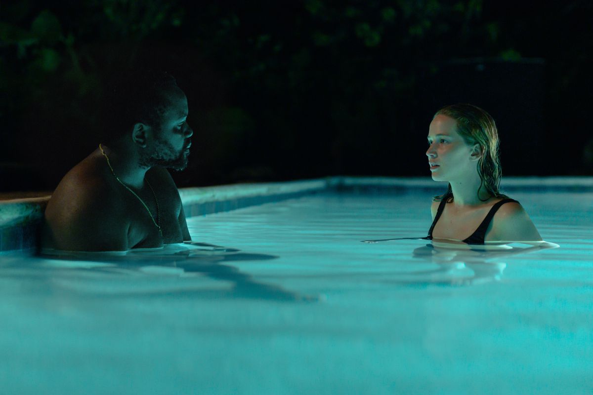 Un uomo (Brian Tyree Henry) seduto in una piscina illuminata di fronte a una donna (Jennifer Lawrence) che nuota di notte.