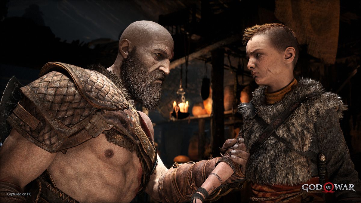Kratos tiene Atreus per un braccio e lo guarda seriamente. Anche Atreus guarda indietro con le sopracciglia aggrottate.